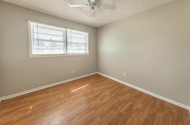 empty room with hardwood / wood-style flooring, ceiling fan, and a textured ceiling