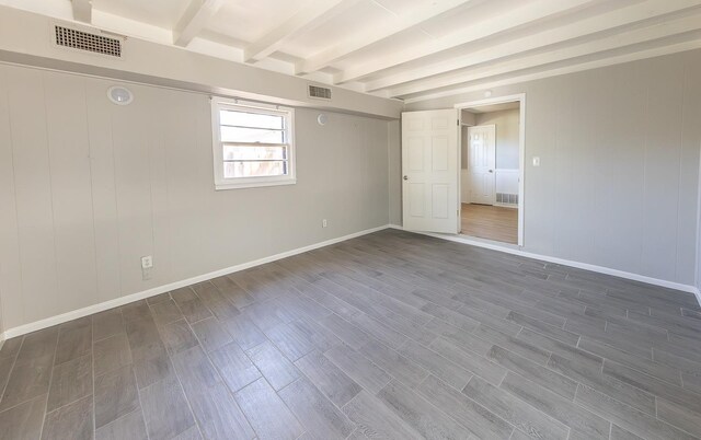 spare room with dark hardwood / wood-style floors and beamed ceiling