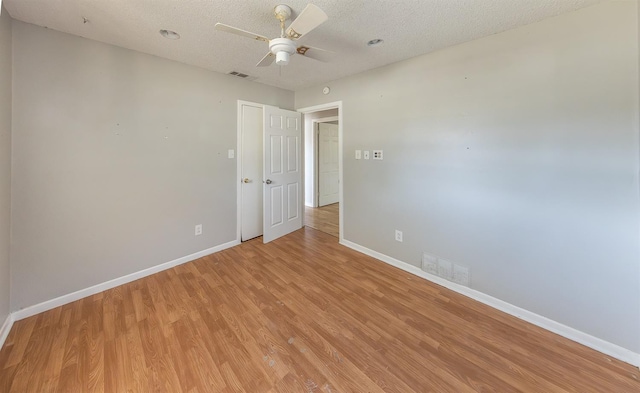 unfurnished room featuring ceiling fan, light hardwood / wood-style floors, and a textured ceiling