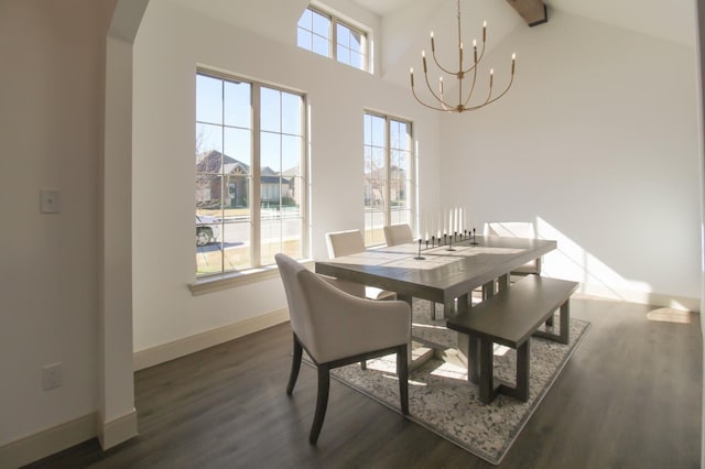 dining area featuring beamed ceiling, dark wood-type flooring, a chandelier, and a towering ceiling