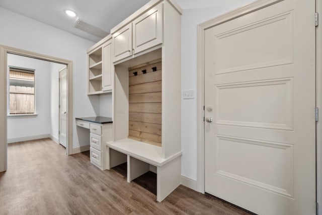 mudroom featuring built in desk and light hardwood / wood-style floors