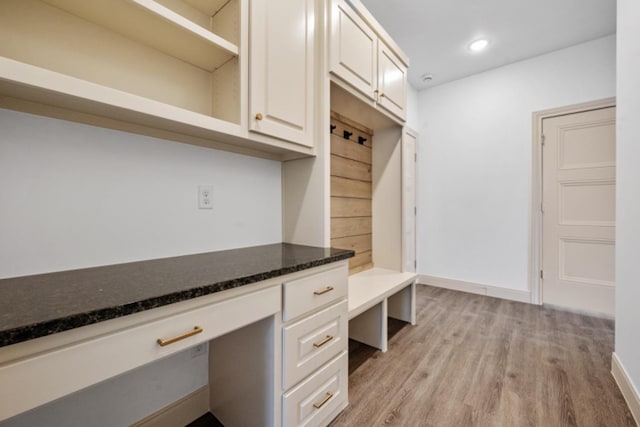 mudroom featuring built in desk and light hardwood / wood-style floors