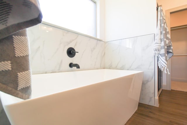 bathroom with hardwood / wood-style floors and a bathing tub