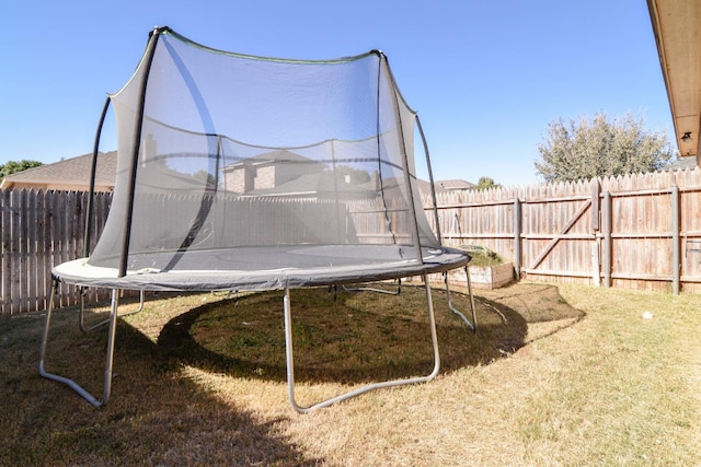 view of play area with a trampoline and a yard