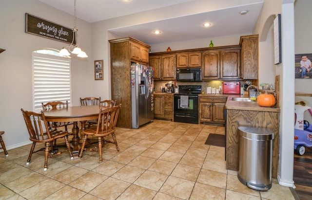 kitchen with sink, tasteful backsplash, light tile patterned floors, pendant lighting, and black appliances