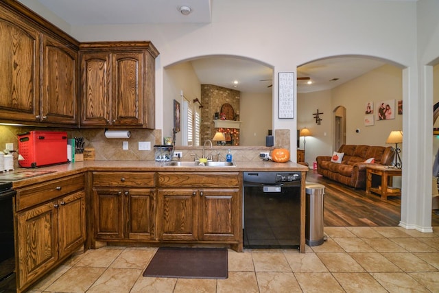 kitchen with black dishwasher, sink, backsplash, range, and light tile patterned floors