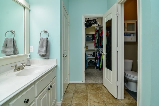 bathroom featuring vanity, tile patterned flooring, and toilet