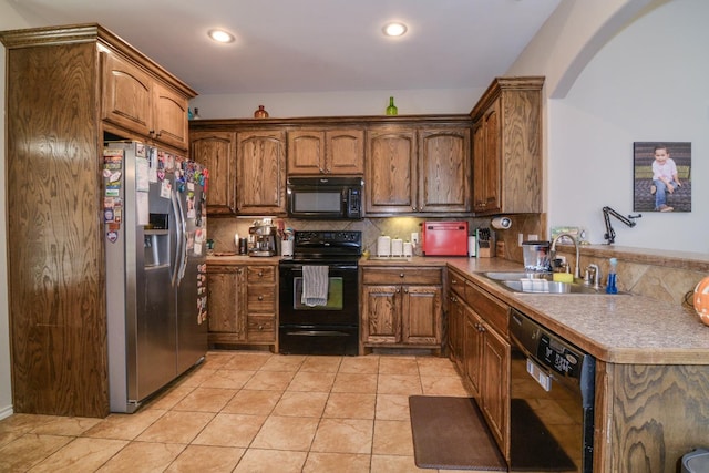 kitchen featuring tasteful backsplash, light tile patterned flooring, sink, and black appliances