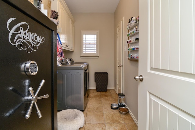 washroom featuring light tile patterned floors, cabinets, and washing machine and clothes dryer