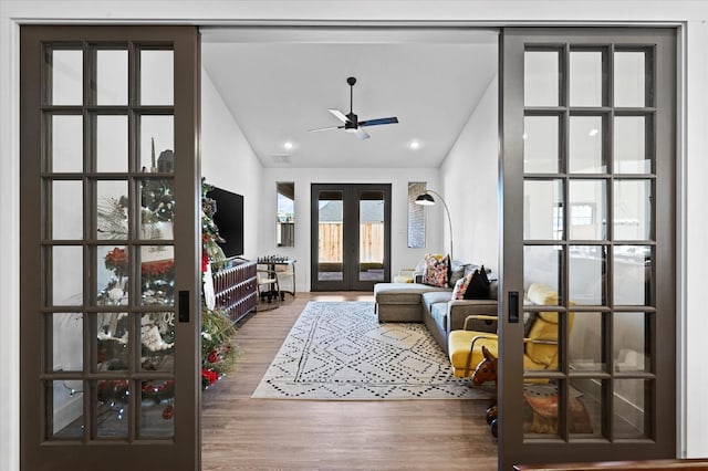 living room with vaulted ceiling, hardwood / wood-style floors, ceiling fan, and french doors