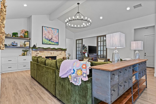 living room featuring lofted ceiling with beams, a notable chandelier, and light hardwood / wood-style floors