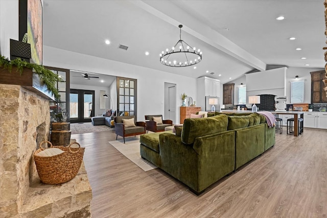 living room featuring french doors, a wealth of natural light, light hardwood / wood-style floors, and vaulted ceiling with beams