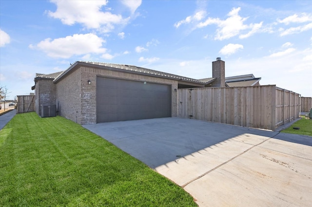 view of front of property featuring a garage, central AC, and a front yard