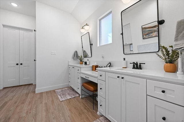 bathroom featuring vanity, vaulted ceiling, and hardwood / wood-style floors