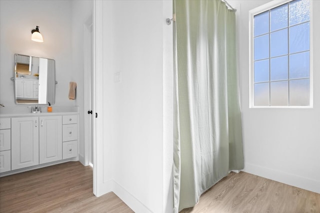 bathroom with wood-type flooring, a wealth of natural light, and vanity