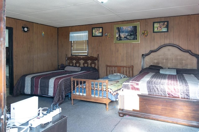 bedroom featuring carpet and wood walls