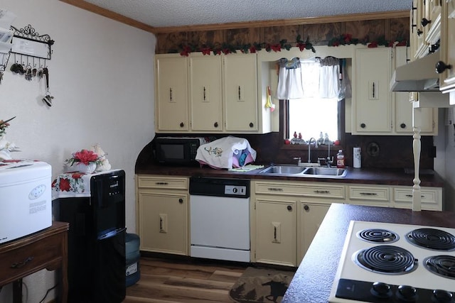 kitchen featuring cream cabinets, sink, a textured ceiling, and white appliances