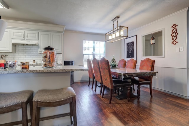 dining room with ornamental molding and dark hardwood / wood-style floors