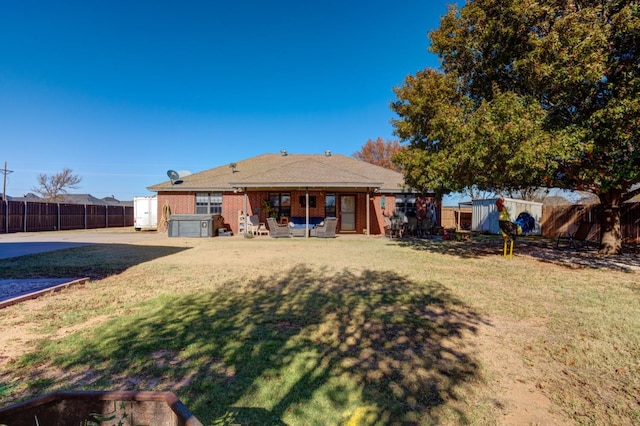 back of property featuring a yard and a storage unit