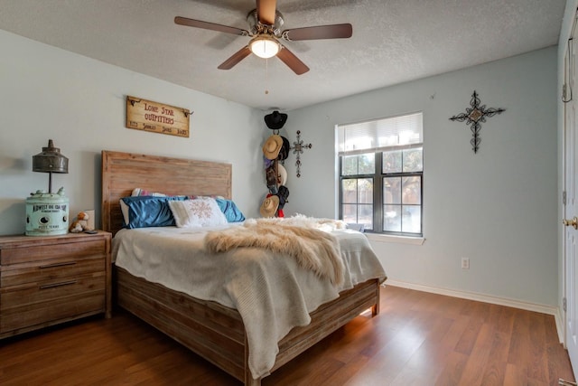 bedroom with ceiling fan, a textured ceiling, and dark hardwood / wood-style flooring