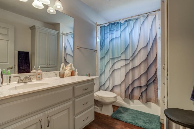 full bathroom with shower / bathtub combination with curtain, vanity, a notable chandelier, wood-type flooring, and toilet