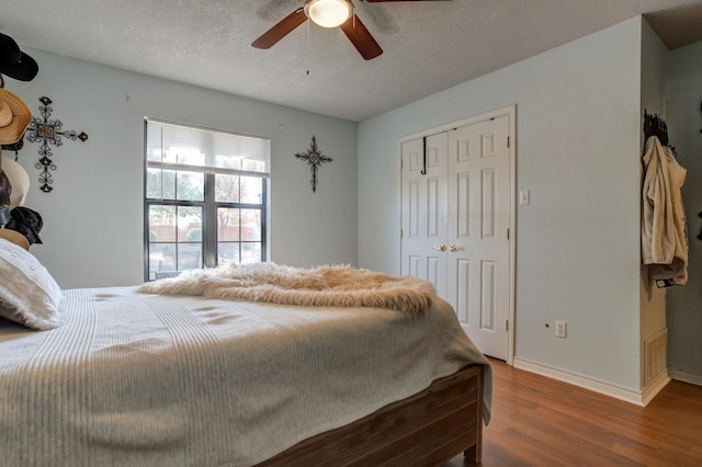 bedroom featuring ceiling fan, a closet, dark hardwood / wood-style flooring, and a textured ceiling