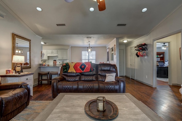 living room with crown molding, dark wood-type flooring, and ceiling fan