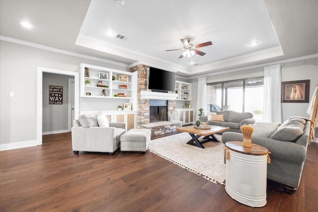 8405 E County Rd 6100, Idalou, TX 79329 - living room with a raised ceiling, dark wood-type flooring, a ceiling fan, ornamental molding, and a stone fireplace