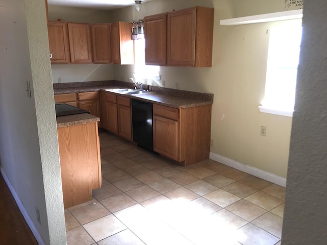 kitchen with a healthy amount of sunlight, black dishwasher, sink, and light tile patterned floors