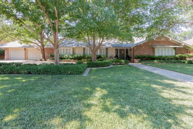 ranch-style home featuring a garage and a front yard