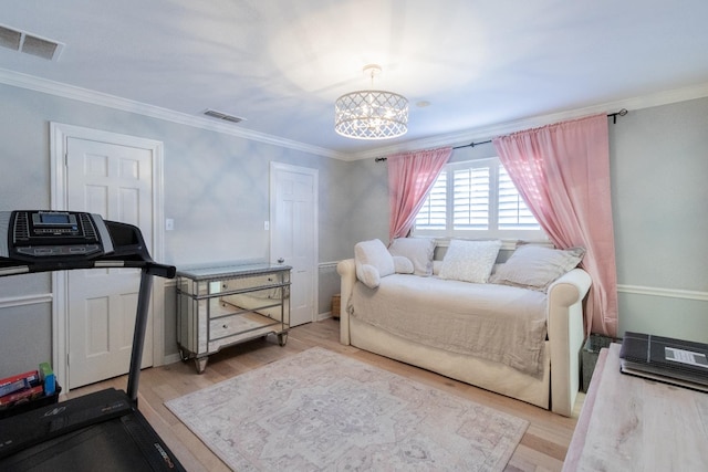 bedroom with light hardwood / wood-style flooring, ornamental molding, and a chandelier