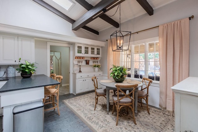 dining space featuring a chandelier and vaulted ceiling with skylight