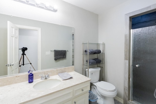 bathroom with vanity, toilet, and a shower with door