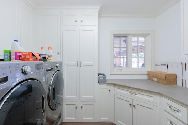 laundry room with crown molding, cabinets, and washing machine and dryer