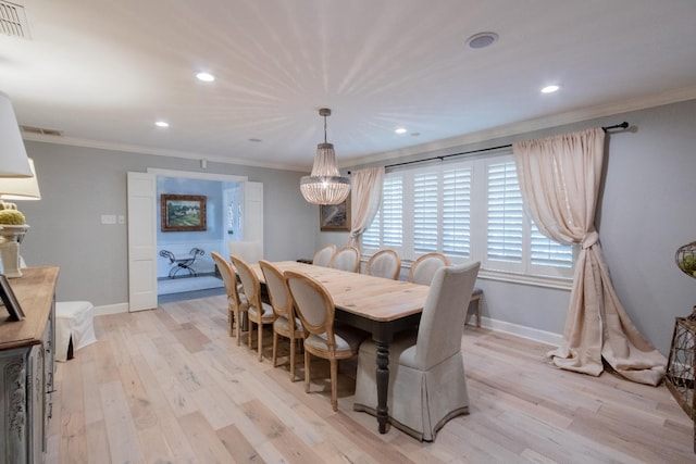 dining area featuring ornamental molding and light hardwood / wood-style flooring