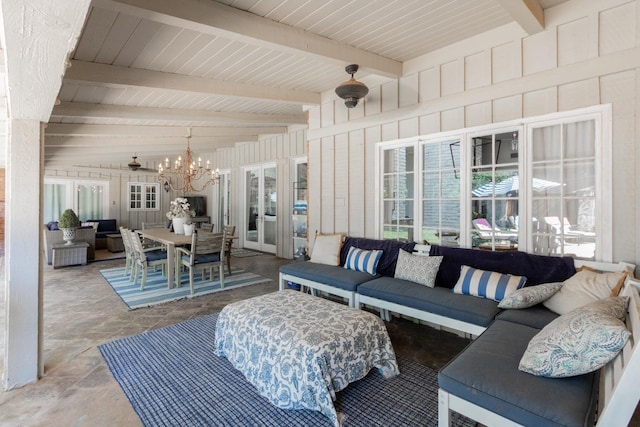 living room with beamed ceiling, wooden walls, and a chandelier