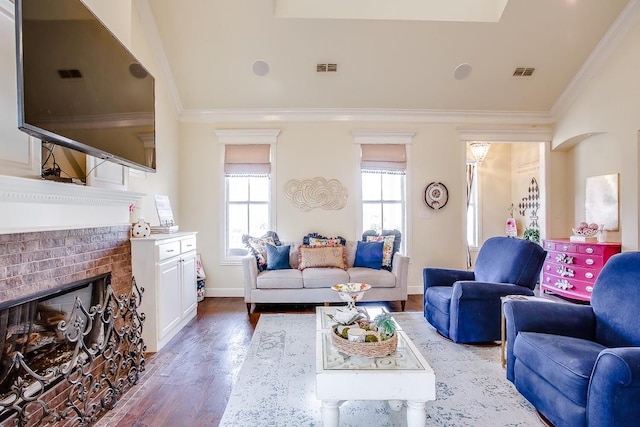 living room with ornamental molding, lofted ceiling, dark hardwood / wood-style floors, and a fireplace