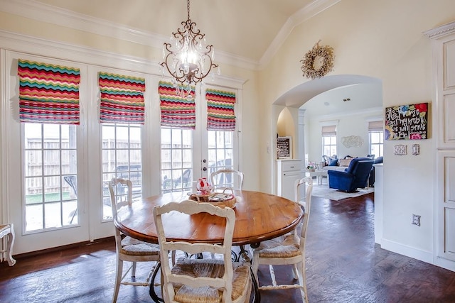 dining room featuring dark wood-type flooring, ornamental molding, a chandelier, and vaulted ceiling