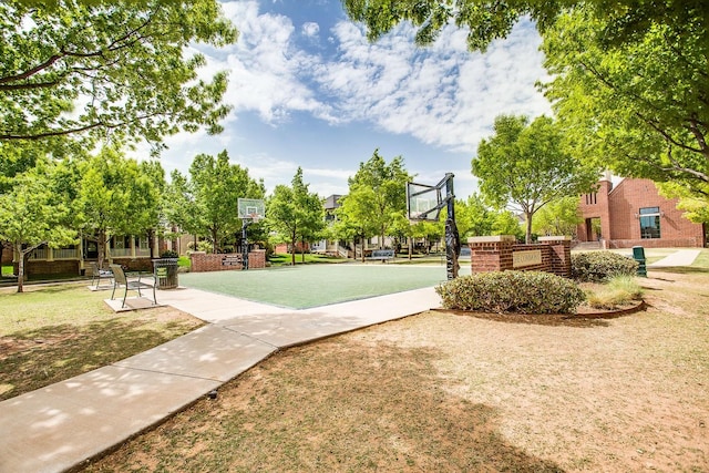 view of property's community featuring basketball court and a lawn