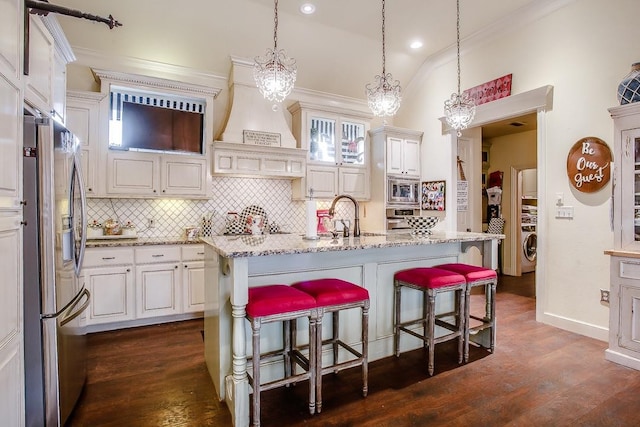 kitchen featuring pendant lighting, sink, a breakfast bar, stainless steel appliances, and a center island with sink