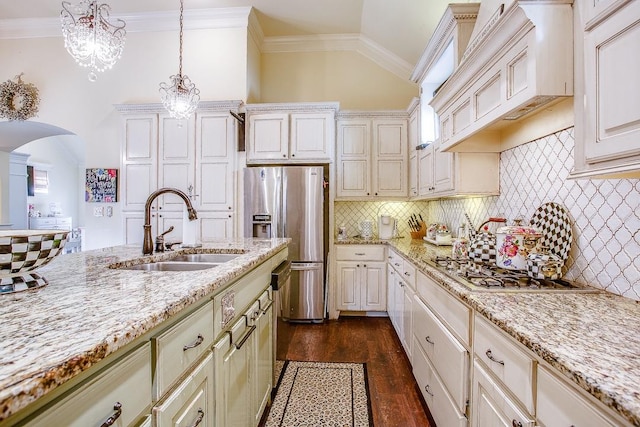 kitchen with appliances with stainless steel finishes, decorative light fixtures, sink, light stone countertops, and custom range hood