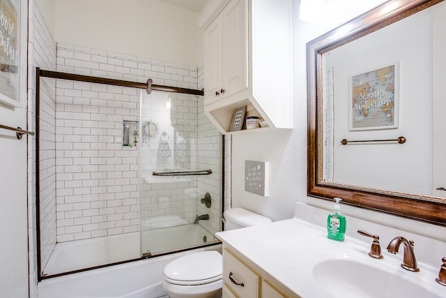 full bathroom with toilet, vanity, and bath / shower combo with glass door