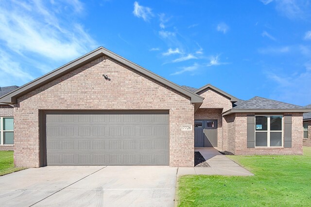 view of front of house with a garage and a front lawn