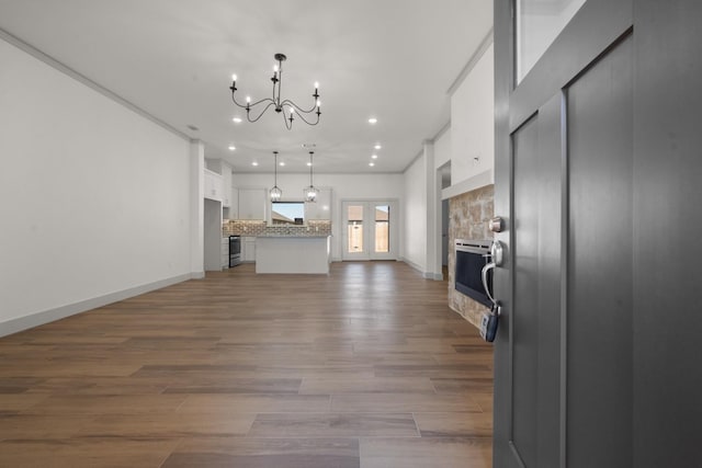 unfurnished living room featuring light wood-type flooring and a chandelier