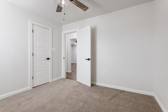 unfurnished bedroom with ceiling fan, carpet floors, and baseboards