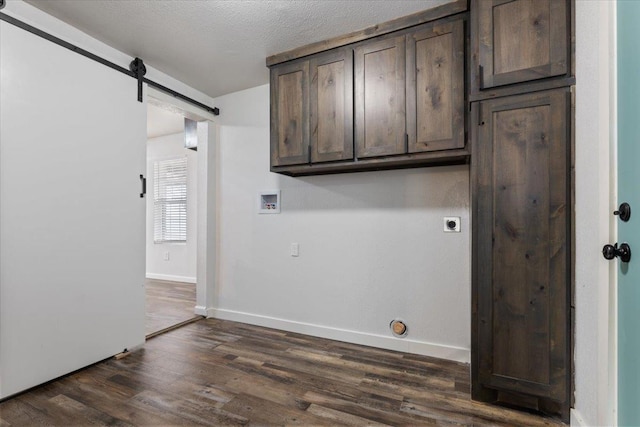 laundry area featuring cabinet space, a barn door, dark wood-style flooring, hookup for an electric dryer, and washer hookup