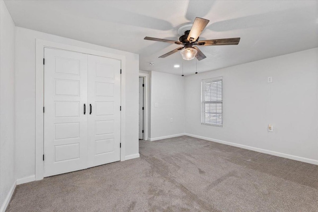 unfurnished bedroom featuring carpet floors, a ceiling fan, baseboards, and a closet