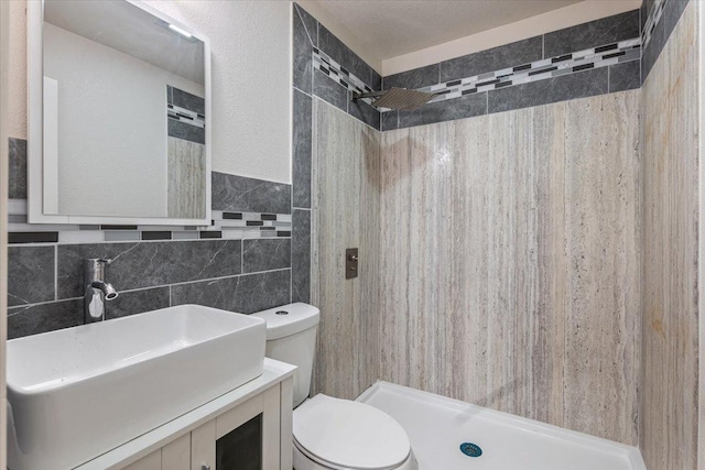 full bathroom with toilet, a shower stall, tile walls, and vanity