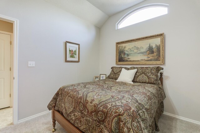 carpeted bedroom with lofted ceiling