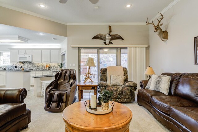 carpeted living room with crown molding and ceiling fan